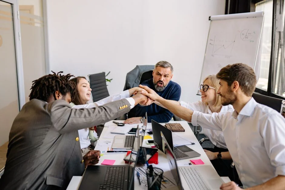 Une équipe diversifiée collabore autour de stratégies de marketing digital à un bureau, en utilisant des ordinateurs portables et des tablettes.